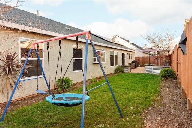 1101 Admiral Ln, Chico, CA 95973 - rear view of house featuring stucco siding, a shingled roof, a fenced backyard, a patio, and solar panels
