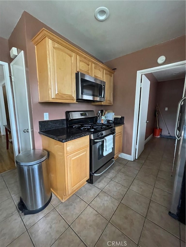 7957 Sausalito Ave, West Hills, CA 91304 - kitchen featuring stainless steel appliances, light tile patterned floors, light brown cabinetry, and dark stone counters