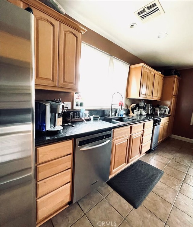 7957 Sausalito Ave, West Hills, CA 91304 - kitchen featuring appliances with stainless steel finishes, dark countertops, light tile patterned floors, and light brown cabinetry