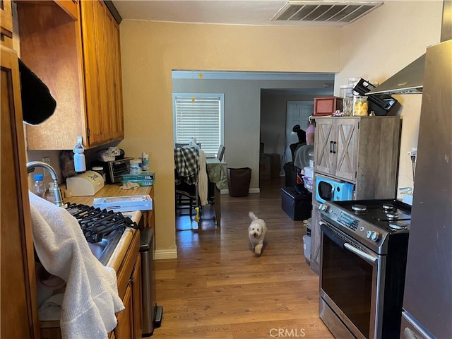 13213 Leffingwell Rd, Whittier, CA 90605 - kitchen featuring electric stove, light wood-style flooring, and brown cabinetry