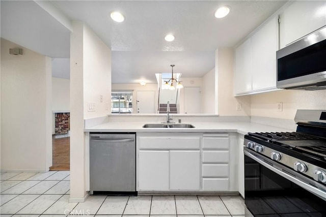 12277 Foster Rd, Norwalk, CA 90650 - kitchen featuring appliances with stainless steel finishes, light countertops, white cabinets, light tile patterned flooring, and pendant lighting