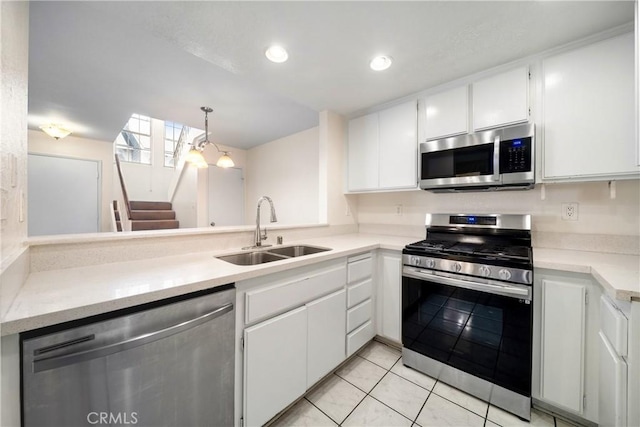 12277 Foster Rd, Norwalk, CA 90650 - kitchen featuring stainless steel appliances, light countertops, white cabinetry, light tile patterned floors, and decorative light fixtures