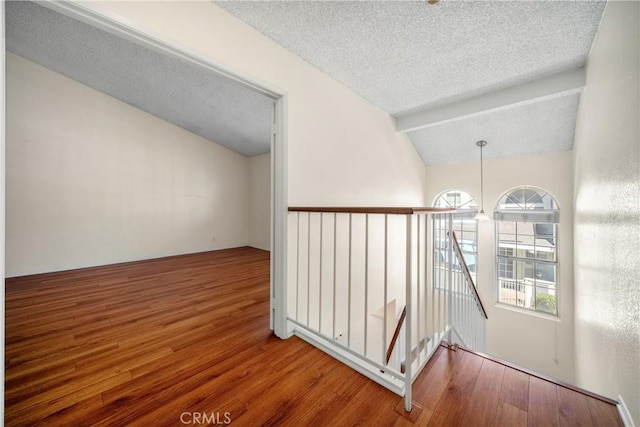 12277 Foster Rd, Norwalk, CA 90650 - hallway with an upstairs landing, wood finished floors, a textured ceiling, and lofted ceiling