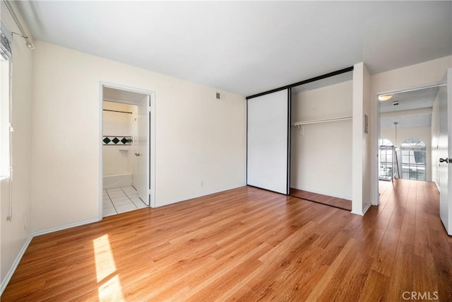 12277 Foster Rd, Norwalk, CA 90650 - unfurnished bedroom featuring wood finished floors, a closet, and connected bathroom