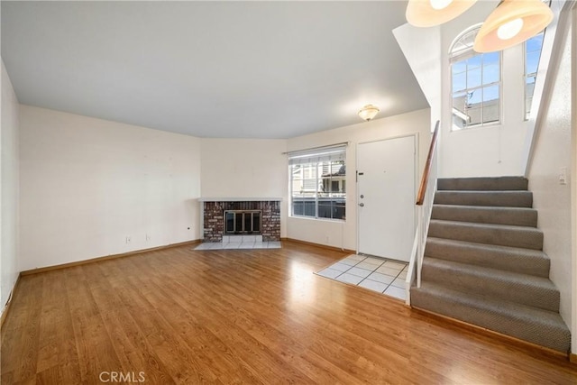 12277 Foster Rd, Norwalk, CA 90650 - unfurnished living room with wood finished floors, stairway, and a fireplace