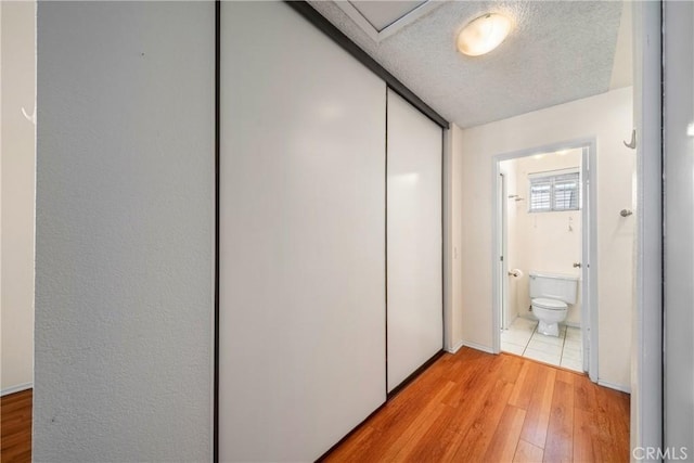 12277 Foster Rd, Norwalk, CA 90650 - hall with light wood-style flooring and a textured ceiling