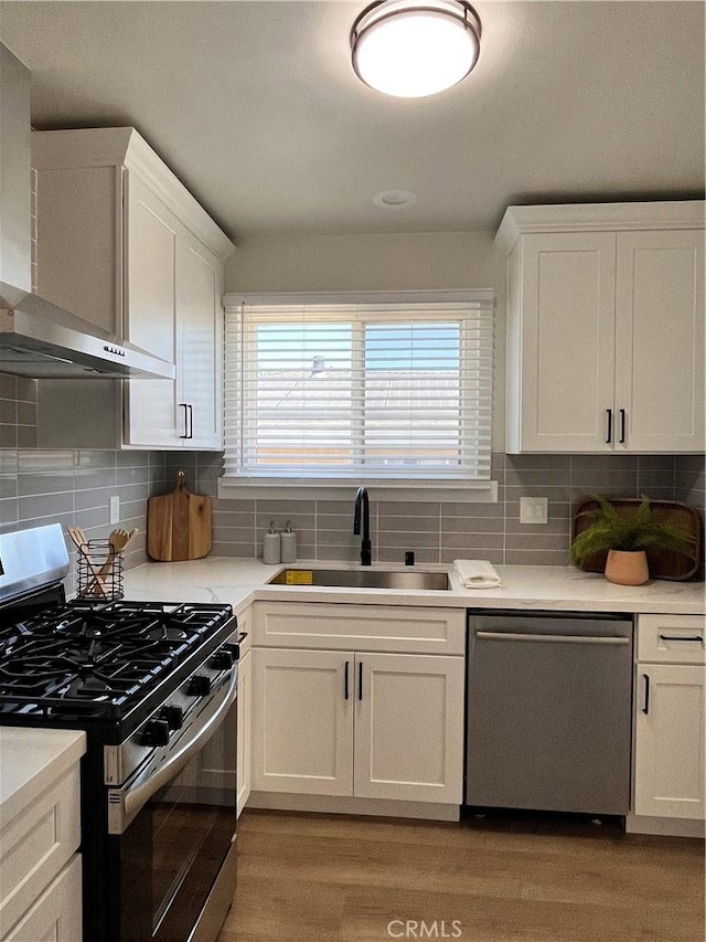 1610 266th St, Harbor City, CA 90710 - kitchen featuring appliances with stainless steel finishes, wall chimney range hood, white cabinets, light wood finished floors, and light countertops