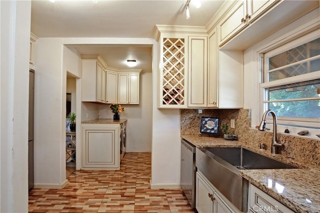 404 N Vinedo Ave, Pasadena, CA 91107 - kitchen with stainless steel dishwasher, cream cabinetry, tasteful backsplash, light stone countertops, and washer / dryer