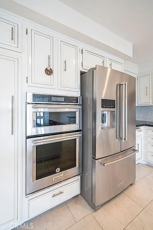 2209 W 25th St Unit 7, San Pedro, CA 90732 - kitchen featuring stainless steel appliances, white cabinets, light tile patterned floors, and backsplash
