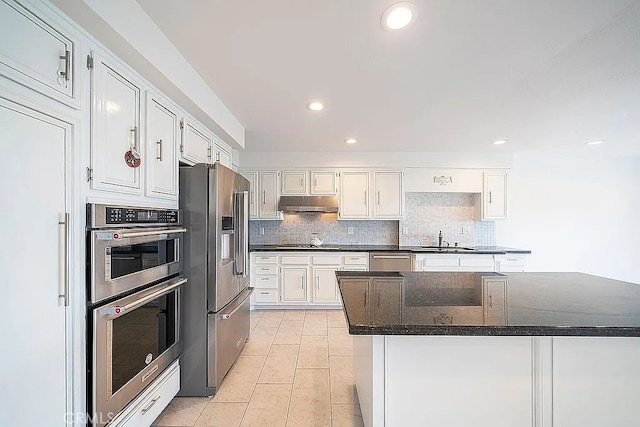 2209 W 25th St Unit 7, San Pedro, CA 90732 - kitchen with appliances with stainless steel finishes, under cabinet range hood, tasteful backsplash, white cabinets, and recessed lighting