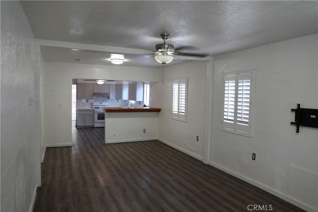 15154 Oliva Ave, Paramount, CA 90723 - unfurnished living room with a ceiling fan, dark wood-style floors, and a textured ceiling