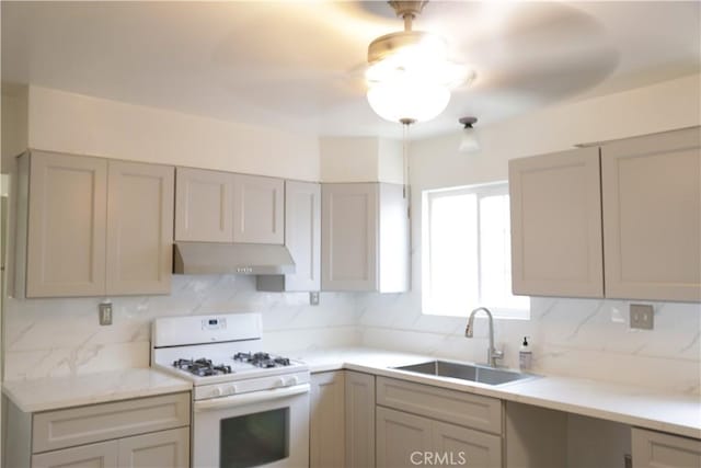 15154 Oliva Ave, Paramount, CA 90723 - kitchen featuring gas range gas stove, under cabinet range hood, decorative backsplash, and light countertops