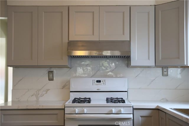 15154 Oliva Ave, Paramount, CA 90723 - kitchen featuring white gas range oven, range hood, decorative backsplash, and gray cabinetry