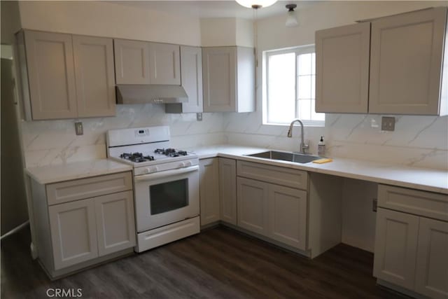 15154 Oliva Ave, Paramount, CA 90723 - kitchen featuring white gas range oven, under cabinet range hood, dark wood finished floors, backsplash, and light countertops