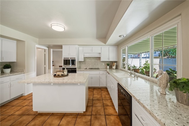 514 Mohawk Dr, Placentia, CA 92870 - kitchen with black appliances, under cabinet range hood, tasteful backsplash, and light tile patterned floors