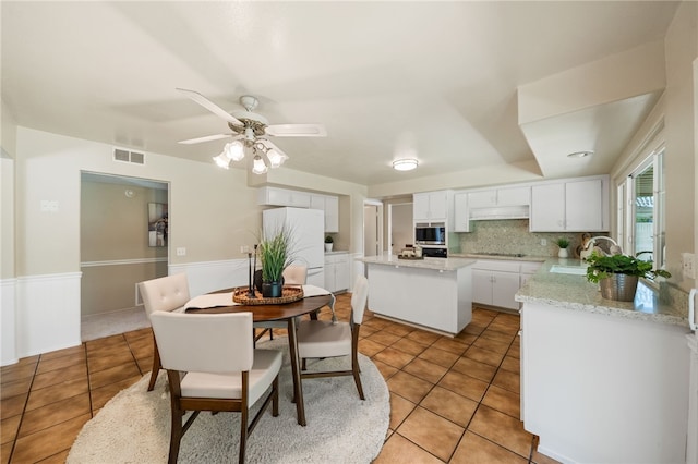 514 Mohawk Dr, Placentia, CA 92870 - dining room with light tile patterned floors, ceiling fan, and a wainscoted wall