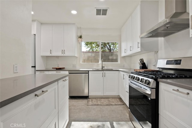 1414 W Jackman St, Lancaster, CA 93534 - kitchen featuring appliances with stainless steel finishes, wall chimney exhaust hood, white cabinetry, and recessed lighting