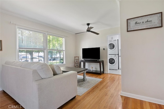 1414 W Jackman St, Lancaster, CA 93534 - living area featuring stacked washing machine and dryer, ornamental molding, a ceiling fan, and light wood-type flooring