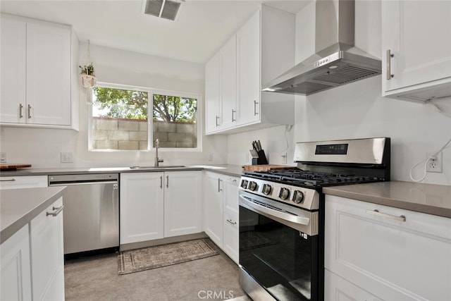 1414 W Jackman St, Lancaster, CA 93534 - kitchen with appliances with stainless steel finishes, wall chimney range hood, and white cabinets