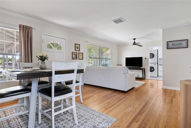 1414 W Jackman St, Lancaster, CA 93534 - living room featuring stacked washer / dryer, crown molding, light wood-type flooring, and ceiling fan