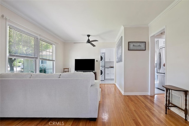 1414 W Jackman St, Lancaster, CA 93534 - living room with estacked washer and dryer, ornamental molding, light wood-style floors, and a ceiling fan