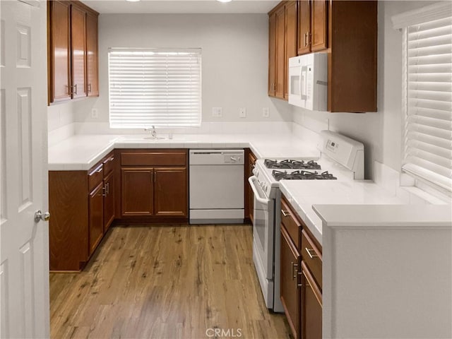 15617 Lasselle St Unit 31, Moreno Valley, CA 92551 - kitchen featuring white appliances, light wood-type flooring, brown cabinetry, light countertops, and recessed lighting