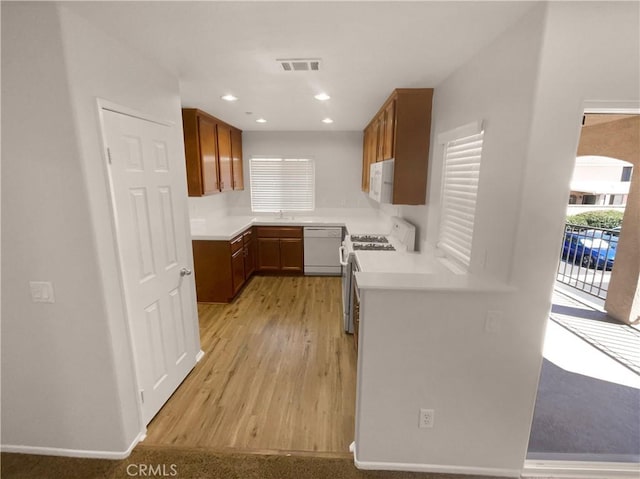 15617 Lasselle St Unit 31, Moreno Valley, CA 92551 - kitchen featuring white appliances, light wood-type flooring, light countertops, brown cabinets, and recessed lighting
