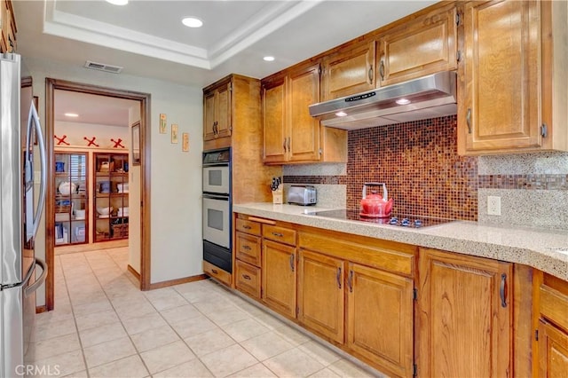 6272 Riviera Cir, Long Beach, CA 90815 - kitchen with under cabinet range hood, freestanding refrigerator, black electric cooktop, decorative backsplash, and recessed lighting