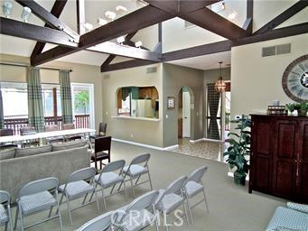 6272 Riviera Cir, Long Beach, CA 90815 - carpeted living area featuring arched walkways and a chandelier
