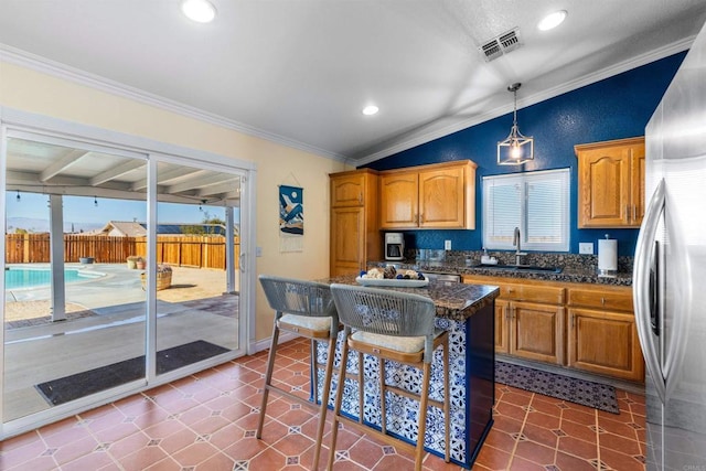 6636 Indian Cove Rd Unit 29, Palms, CA 92277 - kitchen featuring freestanding refrigerator, tile countertops, a center island, a kitchen breakfast bar, and ornamental molding