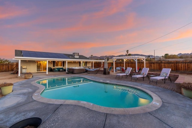 6636 Indian Cove Rd Unit 29, Palms, CA 92277 - pool at dusk featuring a hot tub, a pergola, a fenced backyard, and a patio