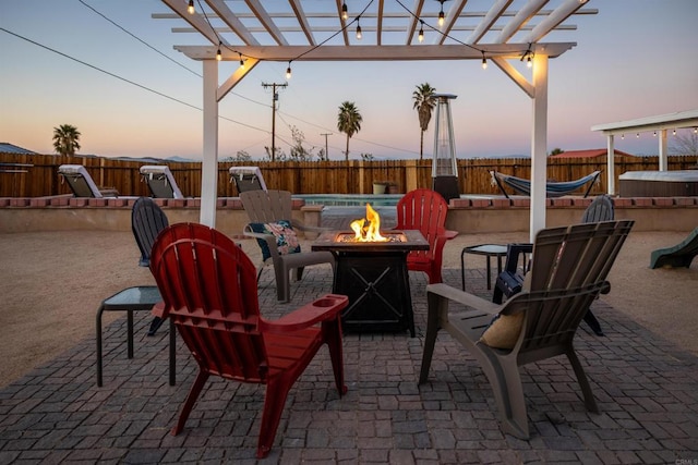 6636 Indian Cove Rd Unit 29, Palms, CA 92277 - patio terrace at dusk featuring an outdoor fire pit, a fenced backyard, a jacuzzi, a patio area, and a pergola
