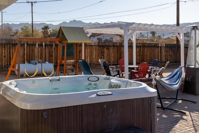 6636 Indian Cove Rd Unit 29, Palms, CA 92277 - view of patio featuring a hot tub, a playground, and a mountain view