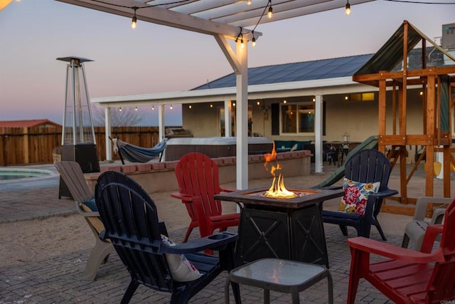 6636 Indian Cove Rd Unit 29, Palms, CA 92277 - patio terrace at dusk featuring an outdoor fire pit, a hot tub, a patio, and a pergola