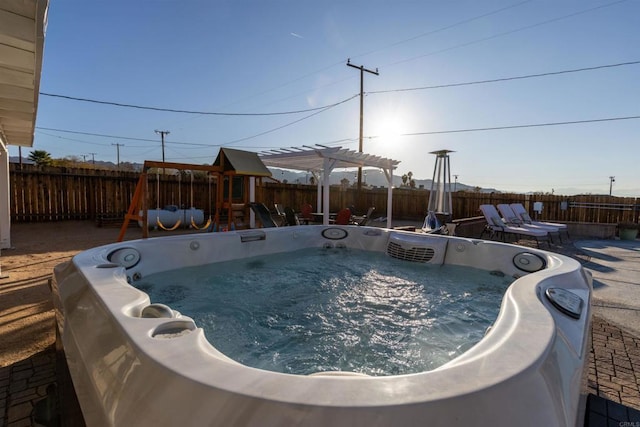 6636 Indian Cove Rd Unit 29, Palms, CA 92277 - view of pool featuring a hot tub, a fenced backyard, a playground, and washer / clothes dryer