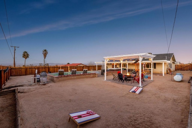 6636 Indian Cove Rd Unit 29, Palms, CA 92277 - yard at dusk featuring a fire pit, a fenced backyard, a pergola, and a patio