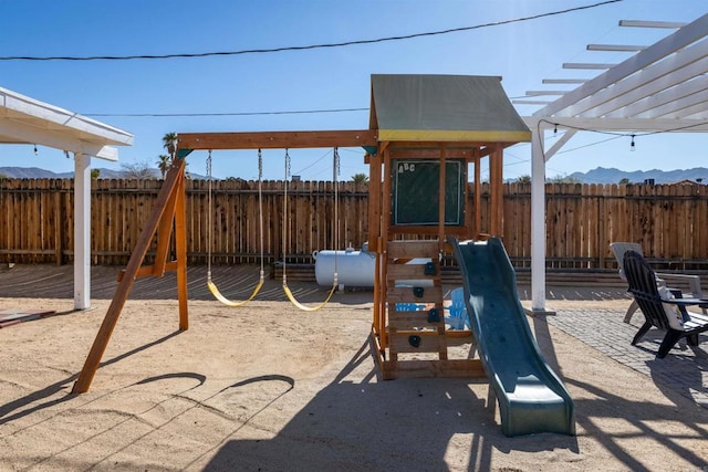 6636 Indian Cove Rd Unit 29, Palms, CA 92277 - view of jungle gym featuring a fenced backyard, a pergola, and a mountain view
