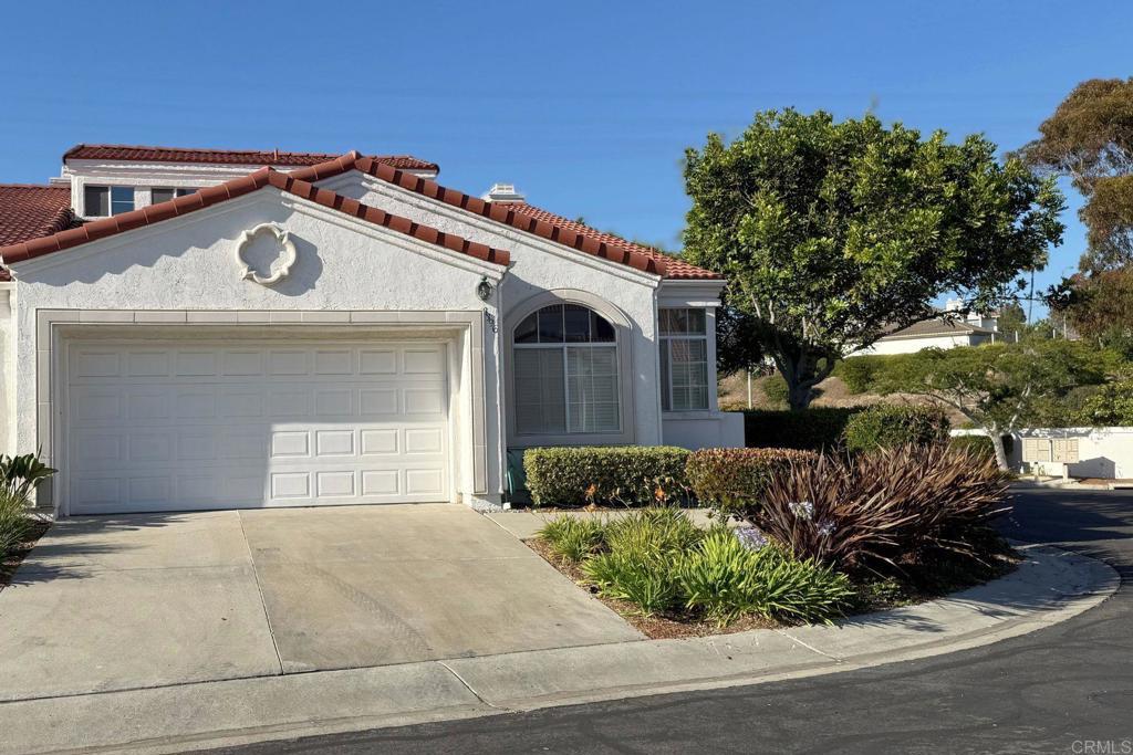 3396 Corsica Way, Oceanside, CA 92056 - mediterranean / spanish-style house with an attached garage, concrete driveway, a tiled roof, and stucco siding