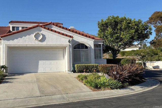 3396 Corsica Way, Oceanside, CA 92056 - mediterranean / spanish-style house with an attached garage, concrete driveway, a tiled roof, and stucco siding