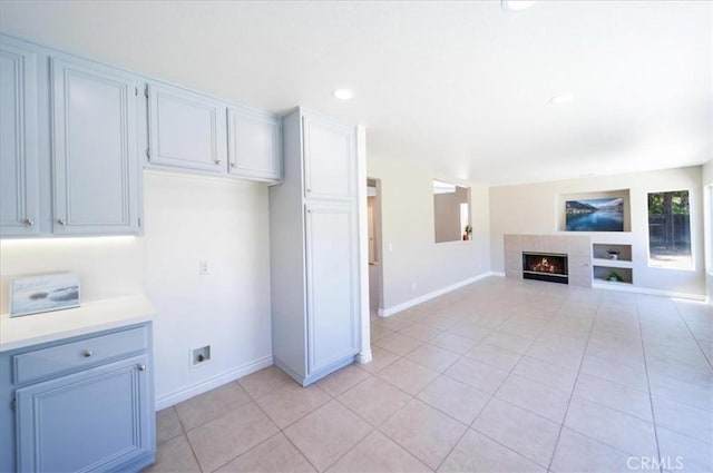 26932 St Julian Cir, Murrieta, CA 92563 - kitchen with light tile patterned floors, light countertops, a tiled fireplace, open floor plan, and recessed lighting