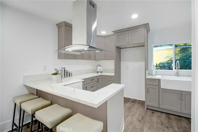 5737 5th, Los Angeles, CA 90043 - kitchen with gray cabinets, island range hood, a peninsula, light stone counters, and recessed lighting