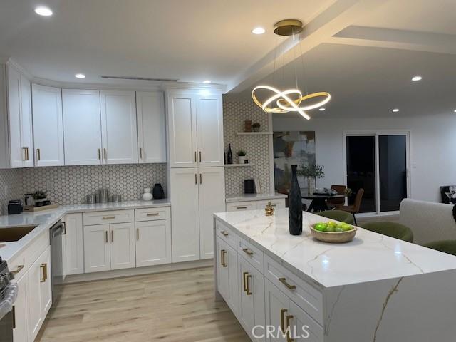 20406 Londelius St, Winnetka, CA 91306 - kitchen featuring open shelves, a chandelier, white cabinetry, light wood-style floors, and backsplash