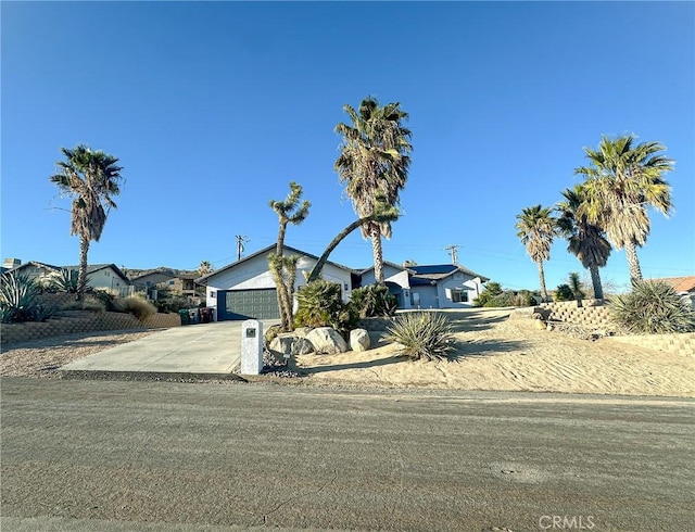 7525 Whitney Ave, Yucca Valley, CA 92284 - view of front of home with concrete driveway and an attached garage