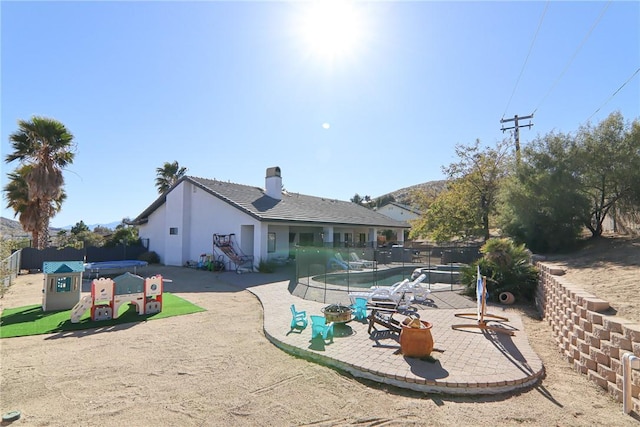 7525 Whitney Ave, Yucca Valley, CA 92284 - rear view of house featuring a patio area, a chimney, and stucco siding