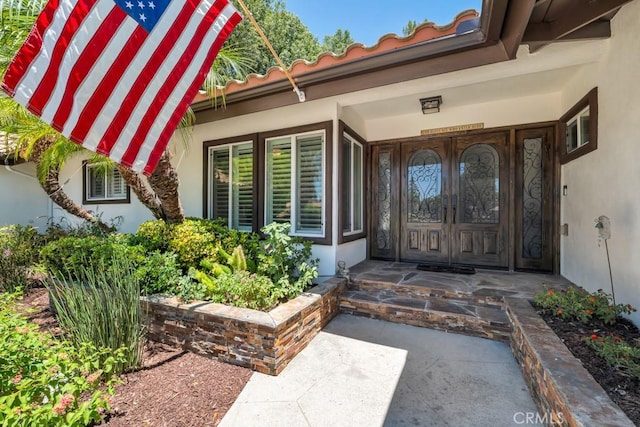 9604 Tunney Ave, Northridge, CA 91324 - doorway to property featuring stucco siding, a porch, and a tiled roof
