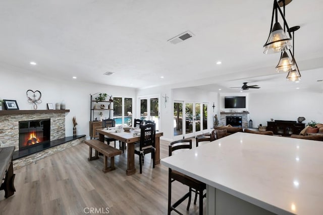9604 Tunney Ave, Northridge, CA 91324 - dining area featuring a stone fireplace, a ceiling fan, light wood-style flooring, and recessed lighting