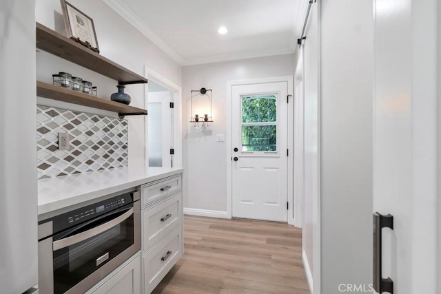 9604 Tunney Ave, Northridge, CA 91324 - kitchen featuring stainless steel oven, white cabinets, light countertops, light wood-style flooring, and backsplash