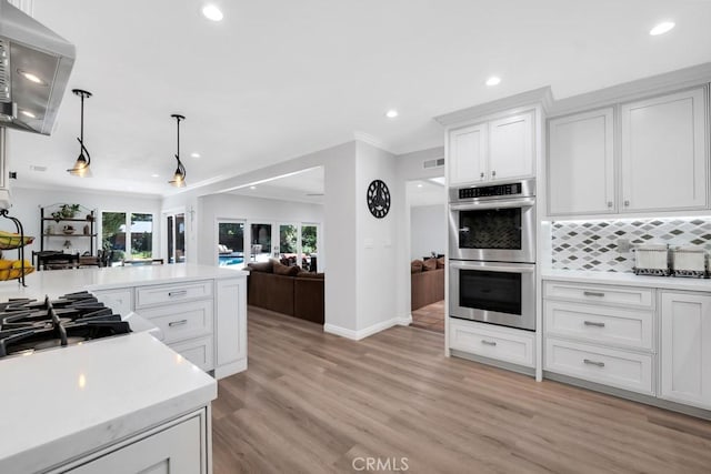 9604 Tunney Ave, Northridge, CA 91324 - kitchen with double oven, light countertops, recessed lighting, open floor plan, and white cabinetry