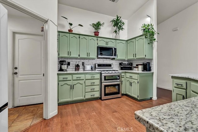 695 Crescent Ln, Lemoore, CA 93245 - kitchen featuring green cabinetry, appliances with stainless steel finishes, backsplash, and light wood-style flooring