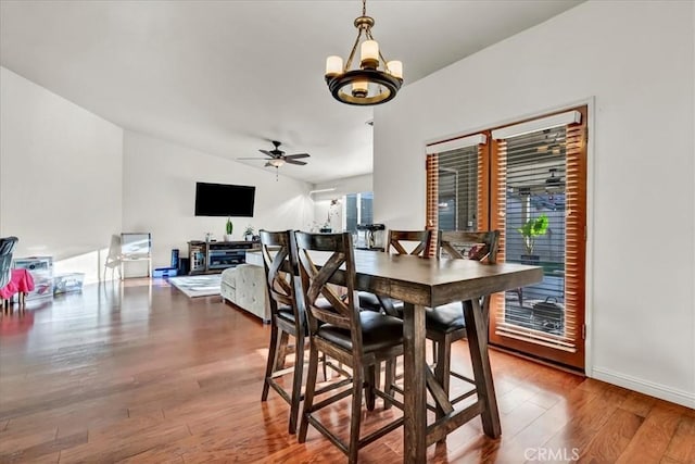 695 Crescent Ln, Lemoore, CA 93245 - dining area featuring wood finished floors, ceiling fan, vaulted ceiling, and a chandelier